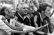 Die Fu&szlig;ball-Weltmeisterschaft in Deutschland: Bundestrainer Helmut Sch&ouml;n (l) versucht an der Seite seines Co-Trainers Jupp Derwall (M) beruhigend auf die Aktionen seiner Mannschaft einzuwirken. Neben ihnen sitzt der ausgewechselte Mittelfeldspieler Herbert Wimmer (r). Die deutsche Fu&szlig;ballnationalmannschaft gewinnt im ausverkauften D&uuml;sseldorfer Rheinstadion das Weltmeisterschaftsspiel der 2. Finalrunde gegen Jugoslawien mit 2:0.