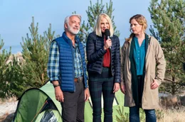 Die hei&szlig;ersehnte Publicity f&uuml;r Camping-Kalle (Christoph M. Ohrt, l.) und Desiree (Diana Amft, r.): Eine Moderatorin (Lena Amende, Mitte) interviewt die beiden f&uuml;rs Fernsehen.