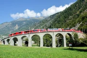 Der Bernina Express f&auml;hrt &uuml;ber das Brusio-Viadukt: Die Viadukte und Tunnel sind steinerne Zeugen f&uuml;r den Pioniergeist der Bahningenieure und den Mut der Bahnarbeiter und Mineure, die trotz der lauernden Gefahren das Schienenband durch die Berge legten.