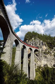 Der Bernina Express bei Alp Gr&uuml;m: &Uuml;ber 196 Br&uuml;cken und durch 55 Tunnel k&auml;mpft sich der Zug von Chur in der Schweiz bis nach Tirano in Italien.