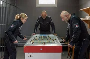 Eine erste heimliche Partie Tischkicker in der Zelle: Bente Hinrichs (Sinha Melina Gierke, l.), Tarkan Yildiz (&Ouml;zg&uuml;r Karadeniz, r.) und Lukas Petersen (Patrick Abozen, M.) sind hochkonzentriert dabei.