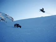 Ein Schneemobil f&auml;hrt um die Wette mit VWs Rally Touareg.