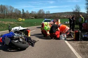 Biker-Unfall auf einer Landstra&szlig;e. Das Rettungsteam k&uuml;mmert sich um den schwer verletzten Motorradfahrer.