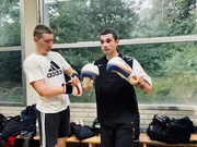 Nikita (l.) kam schon als Kind aus Russland nach Deutschland, der Ukrainer Ivan (r.) fl&uuml;chtete erst vor kurzem vor Krieg und Wehrdienst. Im Boxring k&auml;mpfen die beiden jungen M&auml;nner gegeneinander &ndash; &uuml;ber den Krieg sprechen sie nicht.