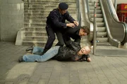 Nach einer wilden Verfolgungsjagd kann Chris (Gedeon Burkhard, Mi.) den fl&uuml;chtigen Brandt (Robert Gallinowski, unten) zwar stellen, wird aber von einem &uuml;bereifrigen Sicherheitsbeamten (Komparse) festgehalten...
