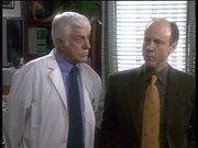 Dr. Mark Sloan (Dick Van Dyke, l.) kann dem vermeintlichen Arzt Frederick Wilson (Jim Ortlieb, r.) nichts nachweisen, obwohl er sich mehrerer Verbrechen schuldig gemacht hat.