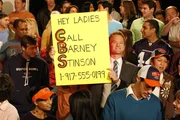 Hat im Football-Stadion ein Schild mit seiner Telefonnummer in die Kamera gehalten und bekommt nun ununterbrochen Anrufe von Frauen, die einen Partner suchen: Barney (Neil Patrick Harris, M.) ...