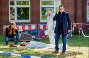 Der Krankenhausclown Fidan Petrov (Philipp Boos, liegend) liegt erschlagen im Hinterhof der Klinik. Die Kommissare Finn Kiesewetter (Sven Martinek, l.) und Lars Engel (Ingo Naujoks, r. mit Christoph Tomanek, 2.v.r.) ) finden heraus, dass der Tote ein Betr&uuml;ger war.
