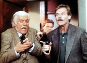 Dr. Mark Sloan (Dick Van Dyke, l.) nimmt an einer Polizeiübung teil, bei der ihn der Polizist Eugene Vicker (John Beck, r.) begleitet. Dr. Mark Sloan (Dick Van Dyke, l.) nimmt an einer Polizeiübung teil, bei der ihn der Polizist Eugene Vicker (John Beck, r.) begleitet.