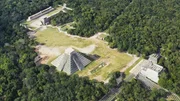 Eine Luftaufnahme zeigt die arch&auml;ologische Anlage von Chich&eacute;n Itz&aacute; mit der Pyramide El Castillo, umgeben von dichtem Wald.