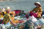 Verkäuferinnen auf dem schwimmenden Markt: Neben den Händlern fahren auch kleine Boote auf dem Fluss, die kühle Erfrischungen, Suppen oder Fingerfood anbieten. Verkäuferinnen auf dem schwimmenden Markt: Neben den Händlern fahren auch kleine Boote auf dem Fluss, die kühle Erfrischungen, Suppen oder Fingerfood anbieten.