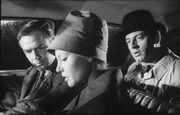 Der m&auml;chtige Apparat von Scotland Yard l&auml;uft an: Nora Ward (Karin Baal), die h&uuml;bsche Assistentin von Inspektor Larry Hold (Joachim Fuchsberger, links), konnte aus der durchtr&auml;nkten Blindenschrift die Worte "Verbrechen" und "Mord" entziffern. Im Fond sitzt Sunny Harvey (Eddie Arent).