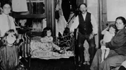 Ein Foto von Jacob Riis, um 1890, das eine Familie zeigt, die in einer Einzimmerwohnung in New York City lebt.