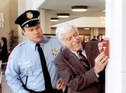 Dr. Sloan (Dick Van Dyke, r.) l&ouml;st zum Schrecken der Sicherheitsleute einen Feueralarm aus.