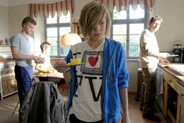 Der kleine Paul (Thilo Berndt, vorne) hat etwas ausgefressen, weshalb er versucht, sich vor dem Fr&uuml;hst&uuml;ck mit seinen Br&uuml;dern Leon (Timm-Marvin Schattling, li.) und Theo (Thibault Serie) und seinem Pflegevater Peter (Michael Fitz) zu dr&uuml;cken.