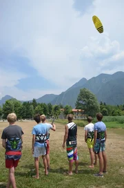 Luc, Leroy, Ole, Trainer, Robin und Nils (v.l.n.r.) &uuml;ben an Land f&uuml;rs Kitesurfen.