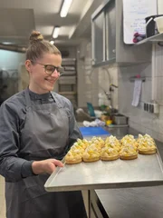 Konditorin J&ouml;rdis Dietel vom &eacute;moi mit einem Tablett frischer T&ouml;rtchen.