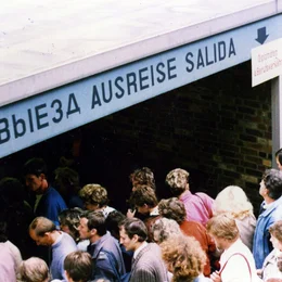 &bdquo;Der absurdeste Bahnhof Berlins&ldquo;, &bdquo;Das Labyrinth des Kalten Krieges&ldquo;, &bdquo;Der Bahnhof der Tr&auml;nen&ldquo;, &bdquo;Die H&ouml;llenpassage&ldquo; - Millionen Deutsche, Ostdeutsche und Westdeutsche, haben hier, am ber&uuml;hmtesten Bahnhof der deutschen Teilung, ihre pers&ouml;nlichen und direkten Grenzerfahrungen gemacht. Der Film erz&auml;hlt erstmals die Geschichte dieses geheimnisvollen Ortes. - Der Eingang in die Ausreisehalle.