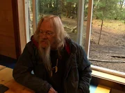 Billy Brown sitting at home next to his window.