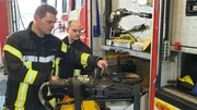 Die Feuerwehrleute bereiten in aller Ruhe die notwendigen Werkzeuge vor, um das Feuer zu l&ouml;schen.