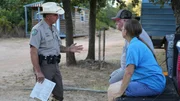Fish and Game Officer Jake Brown speaking to a couple on the farm.