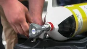 Ein Feuerwehrmann bereitet eine Sauerstoffflasche vor