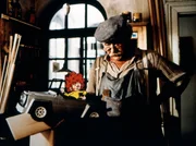 Pumuckl freut sich &uuml;ber das Spielzeugauto, das Meister Eder (Gustl Bayrhammer) ihm geschenkt hat.