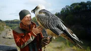 Andreas Kieling steht mit einem Bartgeier in einem Steinbruch in der Eifel. Der Tierfilmer stellt ein erfolgreiches Artenschutzprogramm in den Alpen vor.