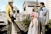 James McKay (Gregory Peck, re.), ein Reederssohn aus Baltimore, kommt nach San Rafael, um die Ranchertochter Pat Terrill (Carroll Baker, Mi.) zu heiraten - sehr zum Missfallen von Verwalter Steve Leech (Charlton Heston, li.), der Pat ebenfalls liebt.