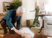 Nadine (Kelly Mullis, r.) sieht entsetzt, wie ein ihr Unbekannter - Dr. Sloan (Dick Van Dyke, l.) - sich &uuml;ber die Leiche ihres Chefs beugt.