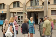 Touristenf&uuml;hrerin Elke Kettler (Tanja Kuntze, 4.v.r.) begr&uuml;&szlig;t eine neue Besuchergruppe in der Markthalle.