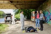Unter einer Br&uuml;cke wird der junge Charlie Lindner gefunden. Jutta Specht (Gabriele Vo?lsch, 2.v.l.) bespricht am Tatort erste Mutma&szlig;ungen mit Pauline Hobrecht (Agnes Decker, 2.v.r.) und Tamara Meurer (Anja Pahl, r.). (Komparsen im Bild)