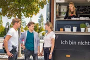 Dominik Morgenstern (Joscha Kiefer, l.) und Resi Schwaiger (Mersiha Husagic, r.) befragen Daniel Steeger (Juri Senft, M.) vor dem Food-Truck von Jana Herzog (Eva N&uuml;rnberg, im Wagen ).
