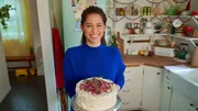 Portrait shot of Molly Yeh with her Norwegian Cream Cake, as seen on Girl Meets Farm, season 9.