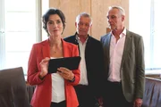 Dr. Aimee Benzweiler (Julia Bremermann, l.) traut Vinz Huber (Michael Roll, M.) und Gregor Becker (Daniel Friedrich, r.) bez&uuml;glich ihres geplanten Hotelprojekts nicht &uuml;ber den Weg.
