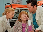 Gertrude Stielke (Gisela Trowe, Mitte) ist beim Verlassen der Klinik über einen Rollstuhl gestürzt. Oberschwester Ingrid (Jutta Kammann) und Dr. Brentano (Thomas Koch, rechts) helfen ihr. Den beiden wird klar, wo Gertrudes Problem liegt - die alte Dame ist fast erblindet. Gertrude Stielke (Gisela Trowe, Mitte) ist beim Verlassen der Klinik über einen Rollstuhl gestürzt. Oberschwester Ingrid (Jutta Kammann) und Dr. Brentano (Thomas Koch, rechts) helfen ihr. Den beiden wird klar, wo Gertrudes Problem liegt - die alte Dame ist fast erblindet.