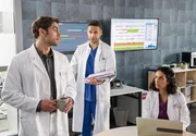 Dr. Sherbaz (Sanam Afrashteh, r.) ist erstaunt, als Dr. Niklas Ahrend (Roy Peter Link, l.) seinen Kollegen Dr. Moreau (Mike Adler, M.) um Hilfe bittet.
