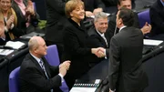 Als erster gratuliert Gerhard Schr&ouml;der der neu gew&auml;hlten Bundeskanzlerin Angela Merkel im Bundestag.