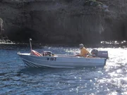 Abalone Sheller Tony Custance on boat near land. Abalone Sheller Tony Custance on boat near land.