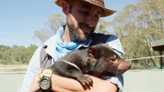 Coyote Peterson holds a tasmanian devil.