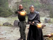Teal'c (Christopher Judge, l.) und Bra'tac (Tony Amendola) er&ouml;ffnen Feuer, jedoch ihre Waffen scheinen dem Gegner kein Leid zuzuf&uuml;gen.