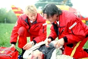 Berger (Serge Falck, l.) und Dr. L&uuml;dwitz (Rainer Grenkowitz, r.) treffen am Unfallort ein und versorgen den verletzten Troger (Christian Oskar Spitzl). Was sie nicht ahnen: Seine Tochter verzweifelt in einem f&uuml;hrerlosen Fesselballon am Himmel...
