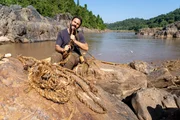 Hazen Audel using banana plant to make rope to build a raft to cross the Mekong River. (National Geographic/Adam Laister)