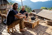Hazen Audel and Ajjee sitting and drinking tea with mountains behind.