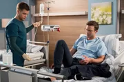 Robert Wenzel (Florian Frowein, r.) kommt mit Bauchschmerzen ins Johannes-Thal-Klinikum. Mikko Rantala (Luan Gummich, l.) legt eine Infusion. Um den Patienten steht es ernster als angenommen.