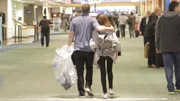 Corey and Evelin walk towards security at the airport.