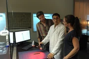 Jan Arnaud (Mike Zaka Sommerfeldt, M.) scannt mit einem Lasercontroller die potentielle Tatwaffe: einen Kubotan. Jo Stoll (Peter Ketnath, l.) und Selma Kirsch (Yve Burbach, r.) beobachten gespannt, ob das Profil des Kubotan auf das Wundmuster der Leiche passt.