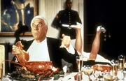 Als Belohnung f&uuml;r die Erschie&szlig;ung des 1000. Drogendealers erh&auml;lt Lt. Frank Drebin (Leslie Nielsen, l.) eine Einladung zum Abendessen beim Pr&auml;sidenten. Mit seinen schlechten Tischmanieren ver&auml;rgert er Frau Pr&auml;sident ...