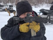 Joey Zuray fires off shots to see how his dog Ace (L) will react to the noise.