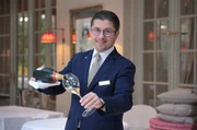 Das Wintergarten-Restaurant im Brenners Park Hotel in Baden-Baden: Darius Wieczorek beim Champagner einschenken.